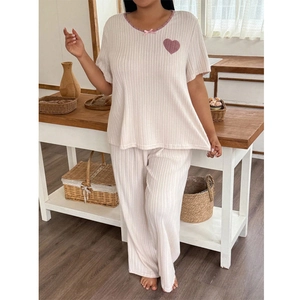 Detail of ribbed pajamas set featuring sweet heart patch and pink bow on neckline