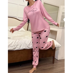 Détail d'un pyjama rose pour femme avec imprimé Love You et motifs de cœurs noirs