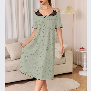 Détail de la nuisette verte à pois avec dentelle noire et nœud sur l'encolure