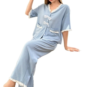 Light blue V-neck pajama set with white lace trim and bow details in a textured fabric