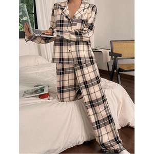 Cozy checkered beige pajama set shown in a modern bedroom setting with a laptop