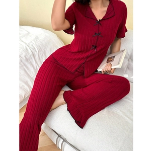 Pijama de rayas rojas con cuello de solapa, lazos negros y dobladillo con volantes