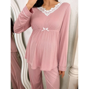 Detailed view of pink maternity pajamas with lace V-neck and soft ribbed knit texture