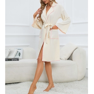 Detail of cream women's robe with pink piping, waffle texture and belted waist