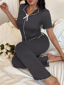 Close-up of short sleeve pajama set with white wavy trim and decorative bow details