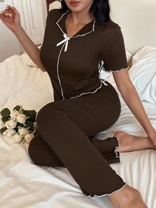 Close-up of brown short-sleeved pajamas with white bow and scalloped trim details