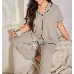 Detail of short-sleeved pajama set with black lettuce edge trim and button-up front