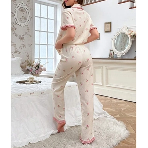 Women's cream floral pajama set with short sleeve top, long pants, and pink ruffle trim