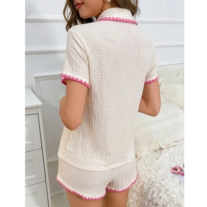 Women's 2-piece cream knit pajama set with pink wavy crochet trim and vertical rib texture