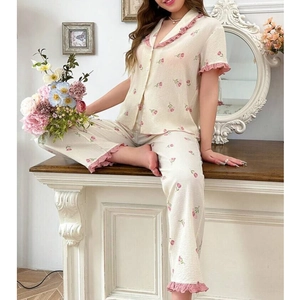 Women's two-piece floral pajama set with short sleeve button top and long pants in cream
