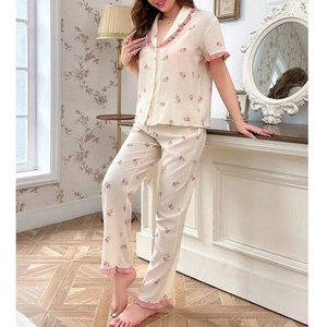 Detail of pink floral pajama set with ruffled edges on a vintage floral background