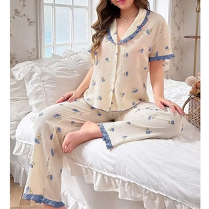 Detail of floral pajama set with blue ruffle trim and lapel collar on breathable fabric