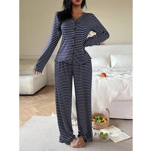 Détail du pyjama à rayures bleues avec col en V boutonné et finitions de l'ourlet ondulé