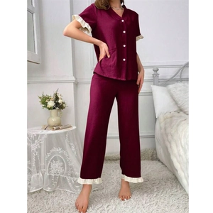 Detail of dark red pajama set with V-neck, white buttons and ruffle hem decorations