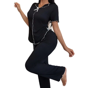 Women's two-piece black short sleeve pajama set with white wavy trim and bow detail