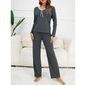 Detail of grey ribbed loungewear featuring delicate white lace trim and bow on V-neckline