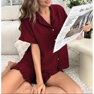 Detail of burgundy short-sleeve pajama set with ruffle trim and white button accents