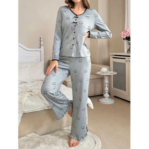 Detail of grey pajama set with cartoon prints, V-neck design, and ruffled cuffs