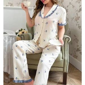 Detail of floral lace short sleeve pajama set on a model sitting in a vintage armchair