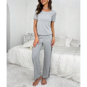 Detail of light gray pajamas set with black contrast trim on sleeves and pant legs