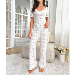 Detail of floral V-neck pajama top with bow and ruffle sleeves in home setting
