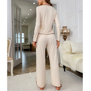 Women's two-piece beige knit pajama set with contrast wavy trim and wide leg pants