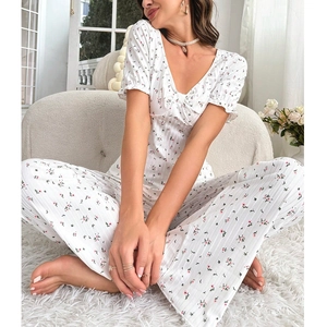 Detail of floral V-neck short sleeve top and wide-leg trousers in textured white fabric
