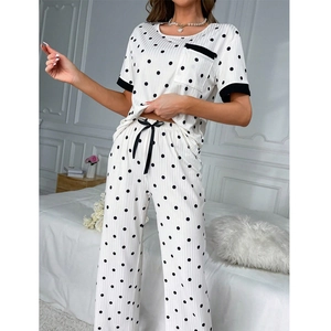 Close-up of white polka dot pajama set featuring ribbed texture and black drawstring details