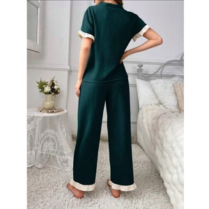 Rear view of dark green waffle knit pajama set with cream ruffle trim on back