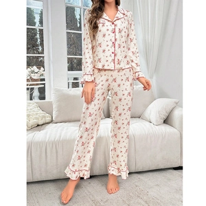 Detailed close-up of floral pajama sleeves with red piping and elegant ruffle cuffs