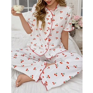 Detail des weißen Pyjamas mit Kirschmuster, roten Rüschenkanten und gerippter Stoffstruktur