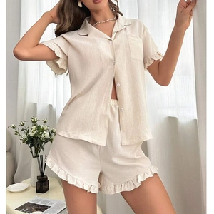 Detail of ruffle trim on beige short-sleeve button-down pajama set with shorts