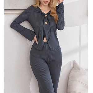 Detailed close-up of dark grey rib-knit fabric with decorative buttons and V-cut hemline