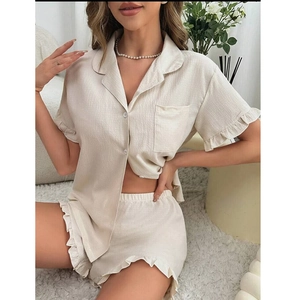 Detail of ruffle trim on apricot textured short sleeve pajama set with buttons