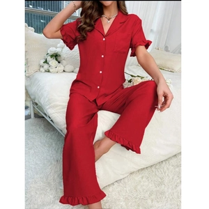 Detail eines roten Damen-Pyjama-Sets mit Rüschenmanschetten und Strukturstoff