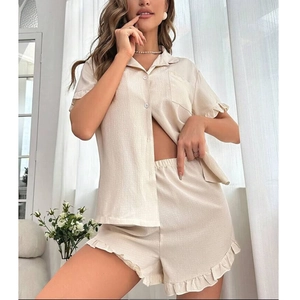 Detail of ruffled edges on cream short sleeve pajama top and shorts with pocket