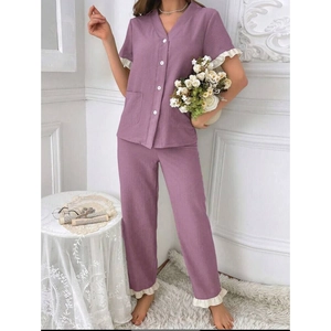 Detail of the purple pajama set featuring white wavy trim and V-neck button-up top