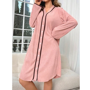 Detailed texture of pink long-sleeved nightdress with brown contrast piping and white buttons