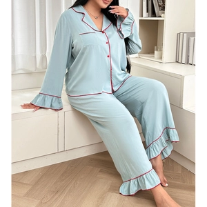 Close-up of ruffled cuffs and red contrast piping on light blue silk pajama set