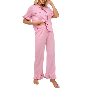 Pink pajama set for women featuring short sleeve V-neck top with red ruffle trim and long pants