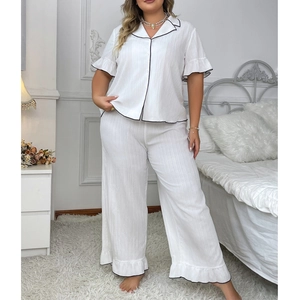 Women's white two-piece pajama set with black piping and ruffle trim on sleeves and pants