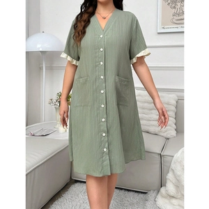 Détail de la robe verte à col en V avec boutons blancs et volants aux manches courtes