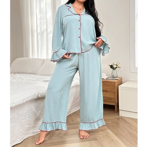 Detail of light blue pajama set featuring red contrast piping and ruffled cuffs