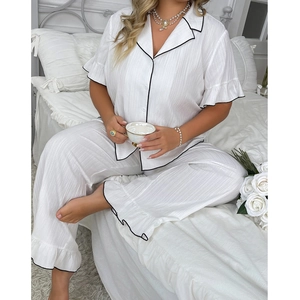 Detail of white short sleeve pajama set with black piping and ruffle edges