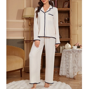 Detail of waffle knit pajama set featuring contrast wavy navy trim and V-neckline texture
