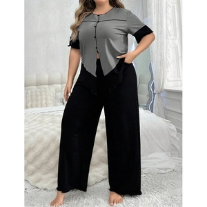 Détail du haut à manches courtes gris et du pantalon large noir en pyjama chic