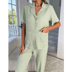 Detail of light green seersucker pajamas with white contrast piping and dual front pockets