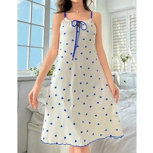 Detail of white summer slip dress with blue heart prints and delicate bow neckline