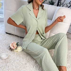 Detail of sage green seersucker pajamas with white contrast piping and textured fabric