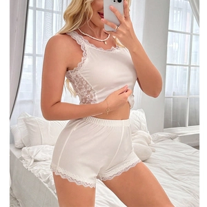 Détail d'un pyjama blanc en maille côtelée avec dentelle délicate et col en v